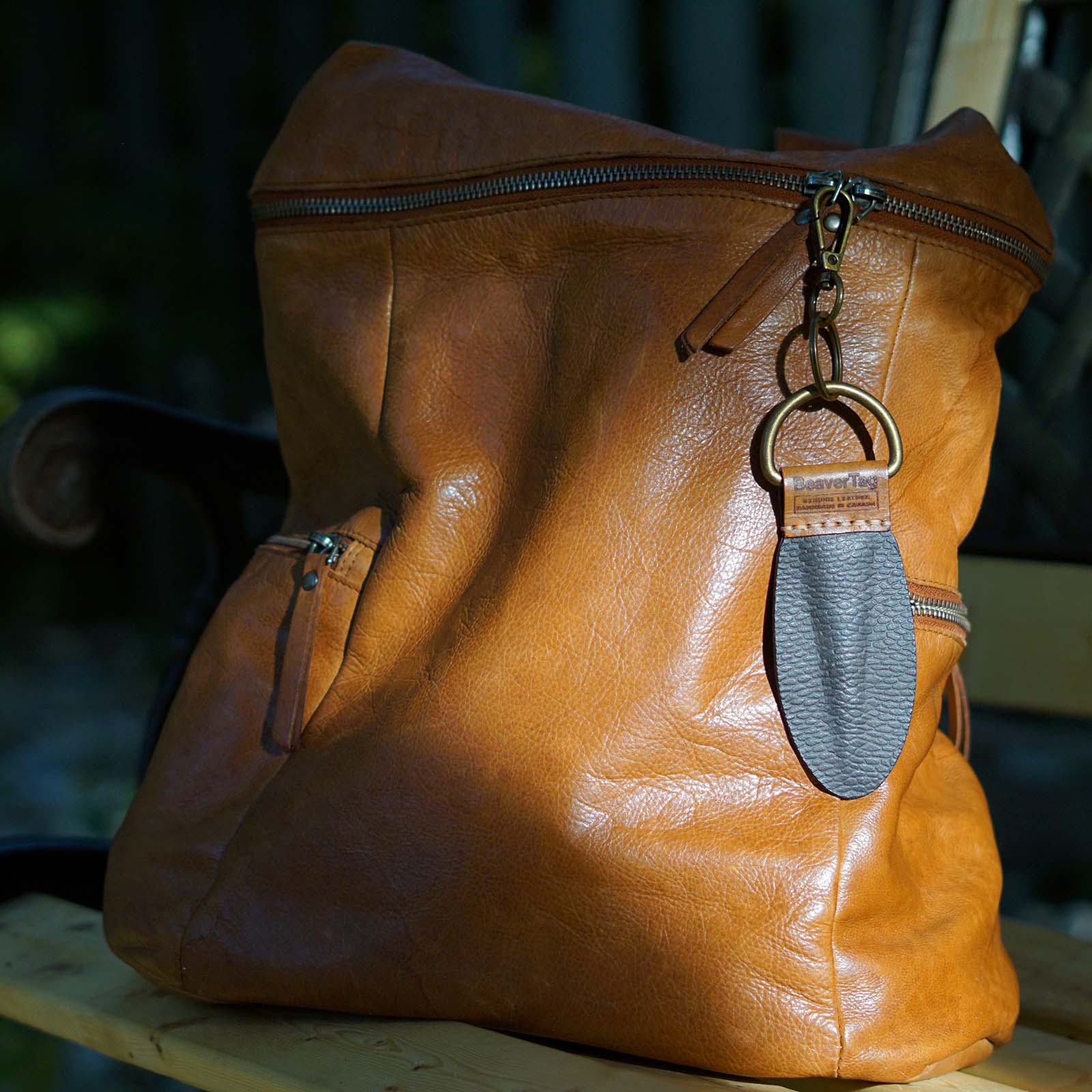 BeaverTag as a bag charm on a leather tote—subtle nod to Canadian identity